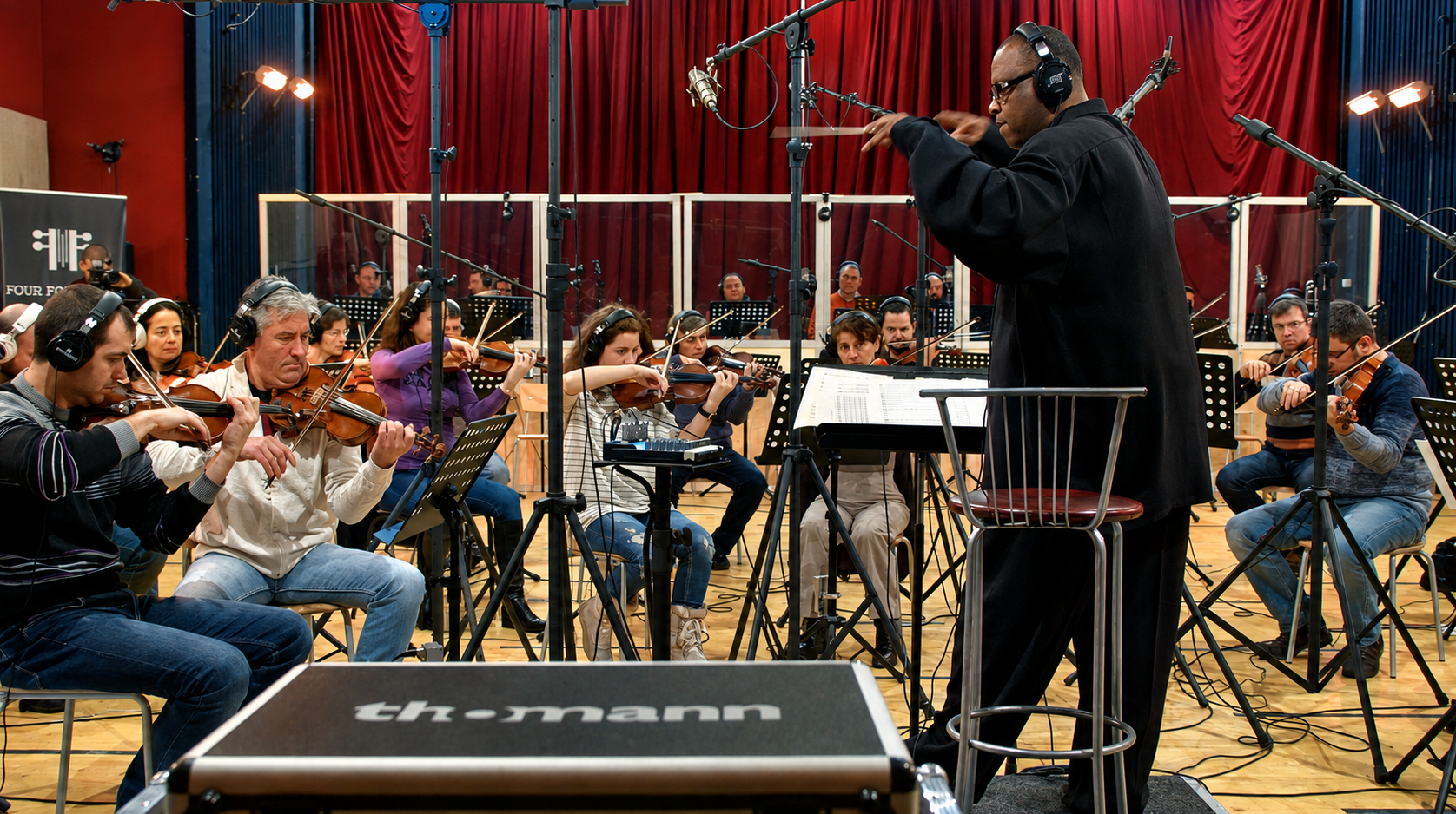 Rob Diggy Morrison conducting an orchestra in a recording studio